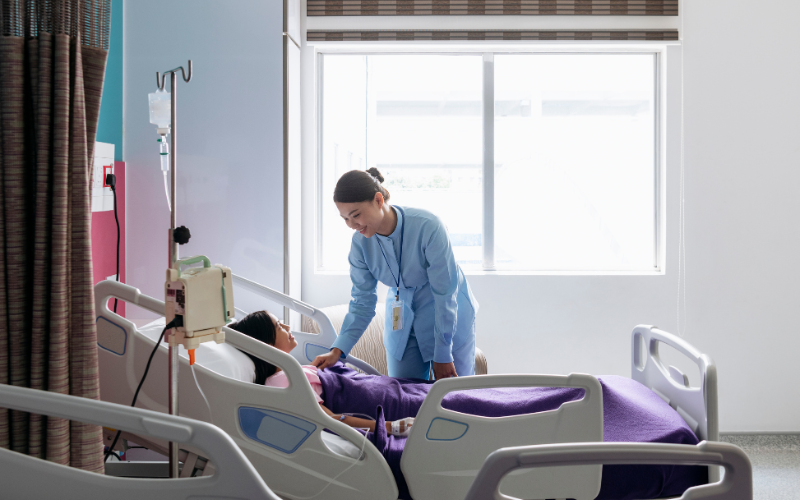 A female nurse attending to a girl in a hospital room